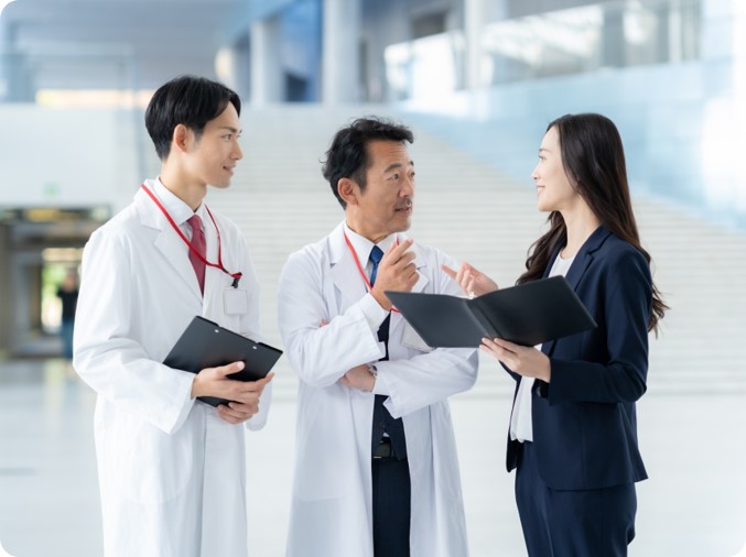 病院で2人の医師と相談をするSEOコンサルタント